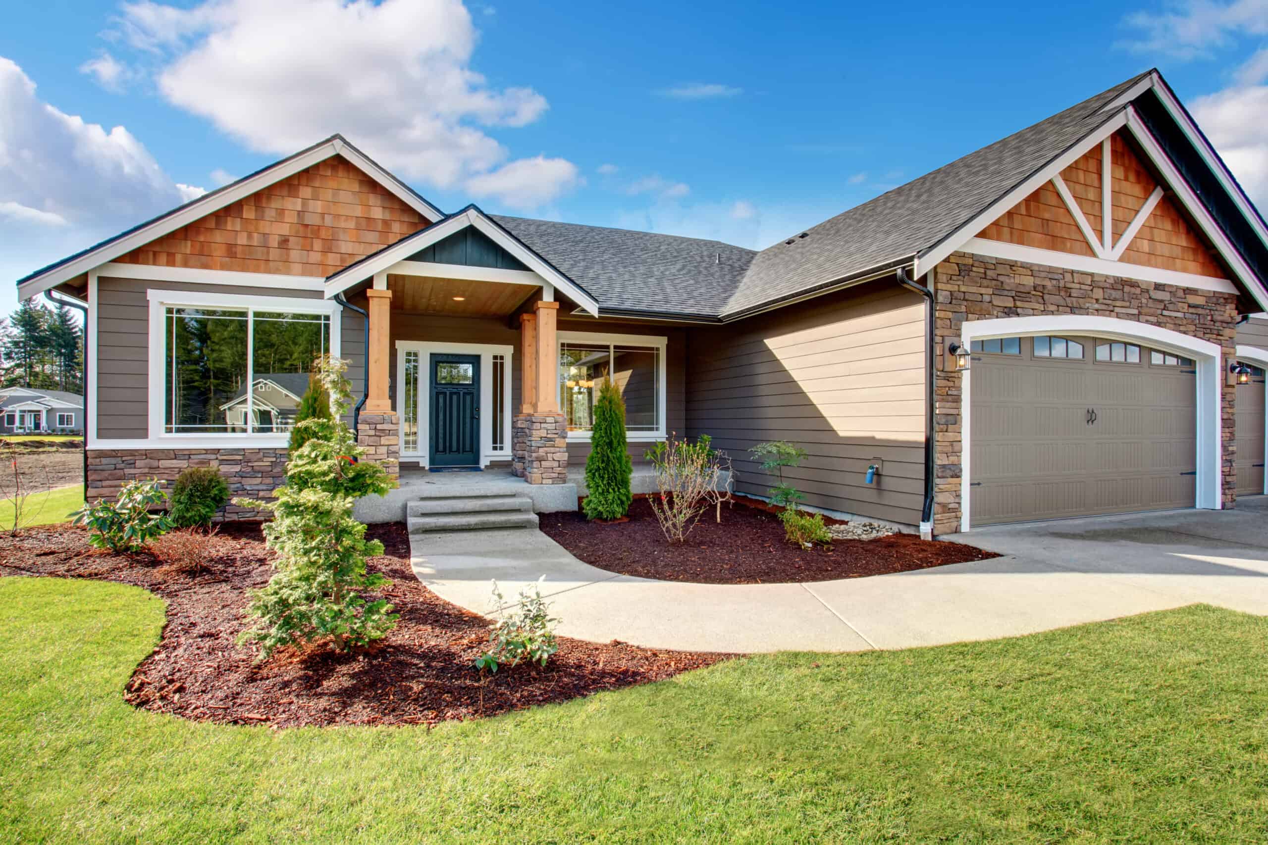 a large cabin with a sidewalk leading to a mulch bed with drought-tolerant vegetation