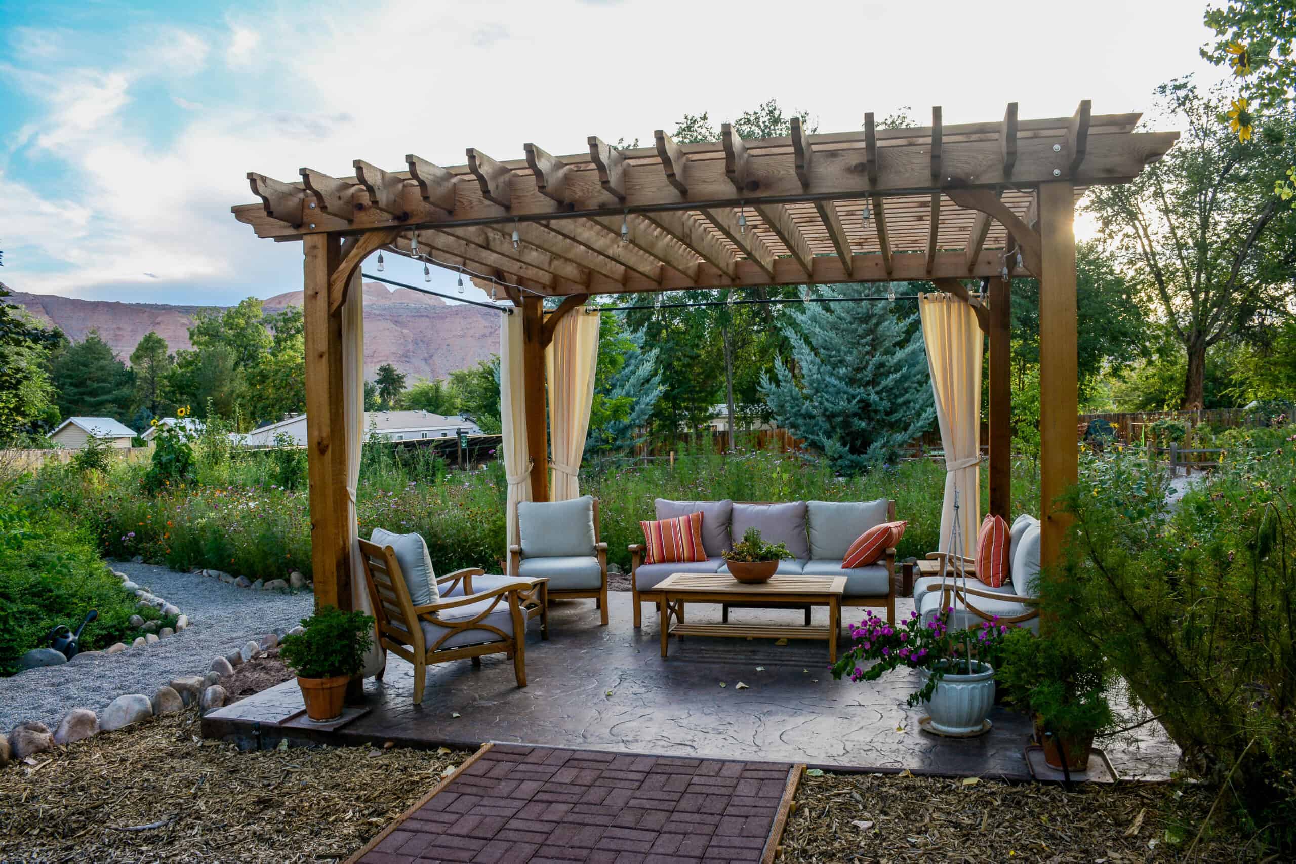 an open pavilion with seating surrounded by the desert mountains and drought-tolerant vegetation