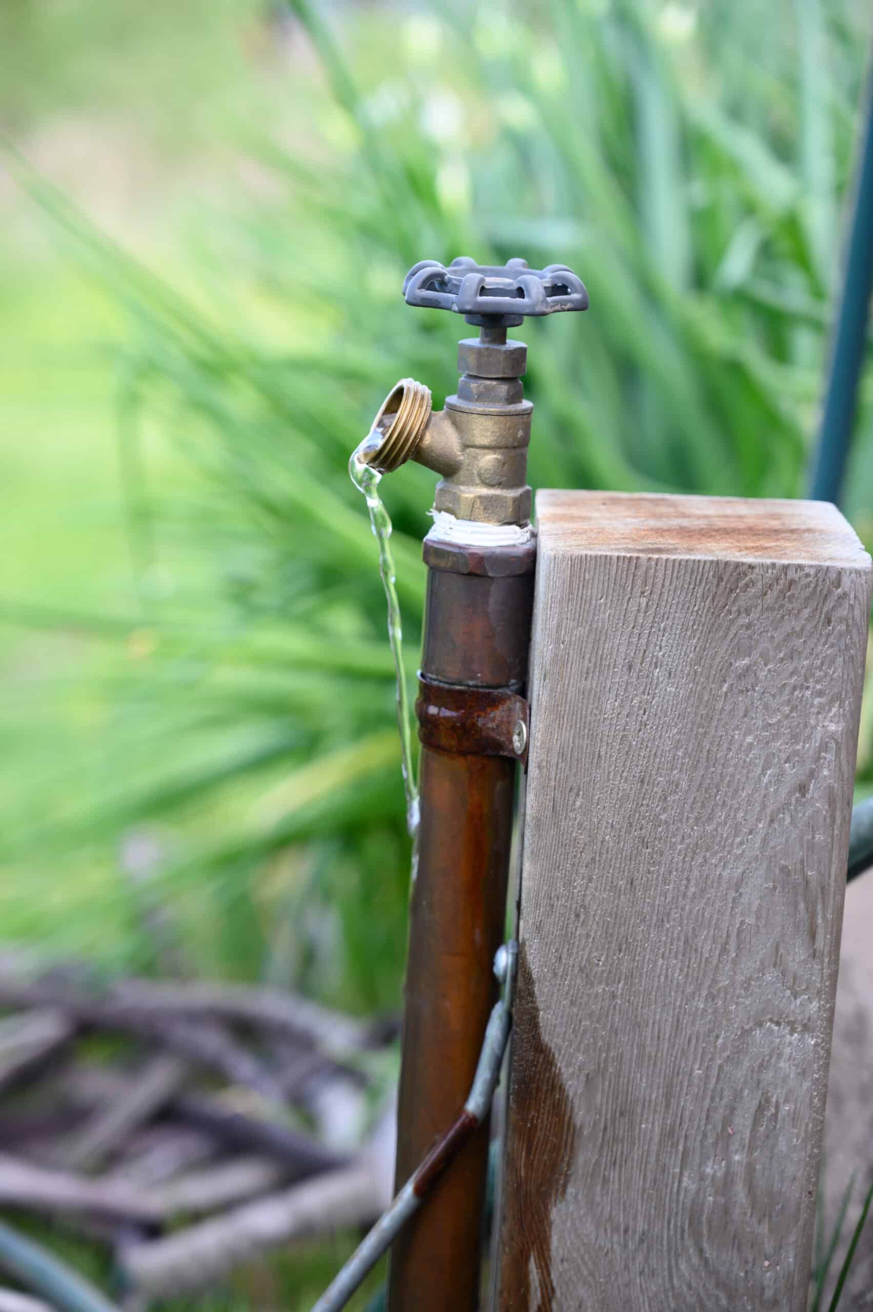 a leaky outdoor faucet attached to a piece of wood