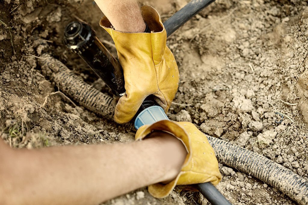 a person turning off their sprinkler system to resolve a flooding issue.