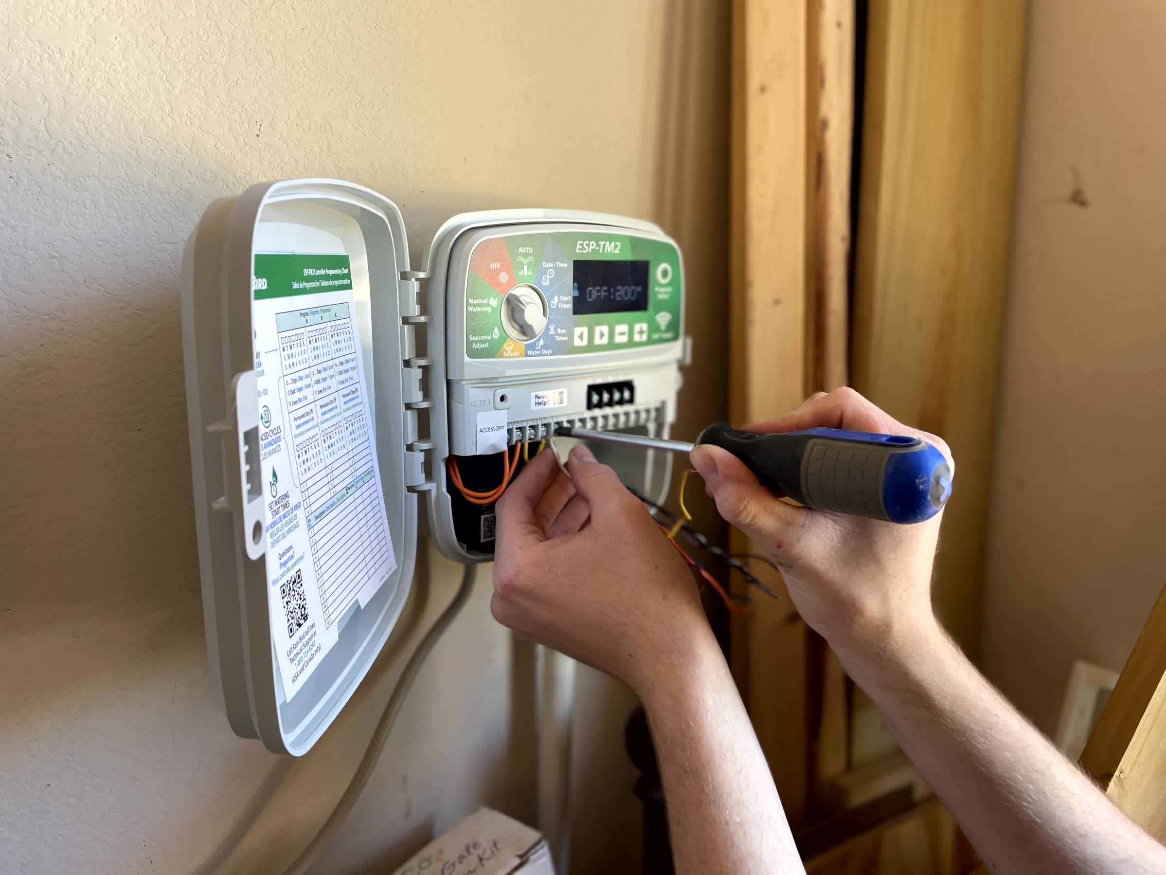 A professional handling an irrigation controller inspection.