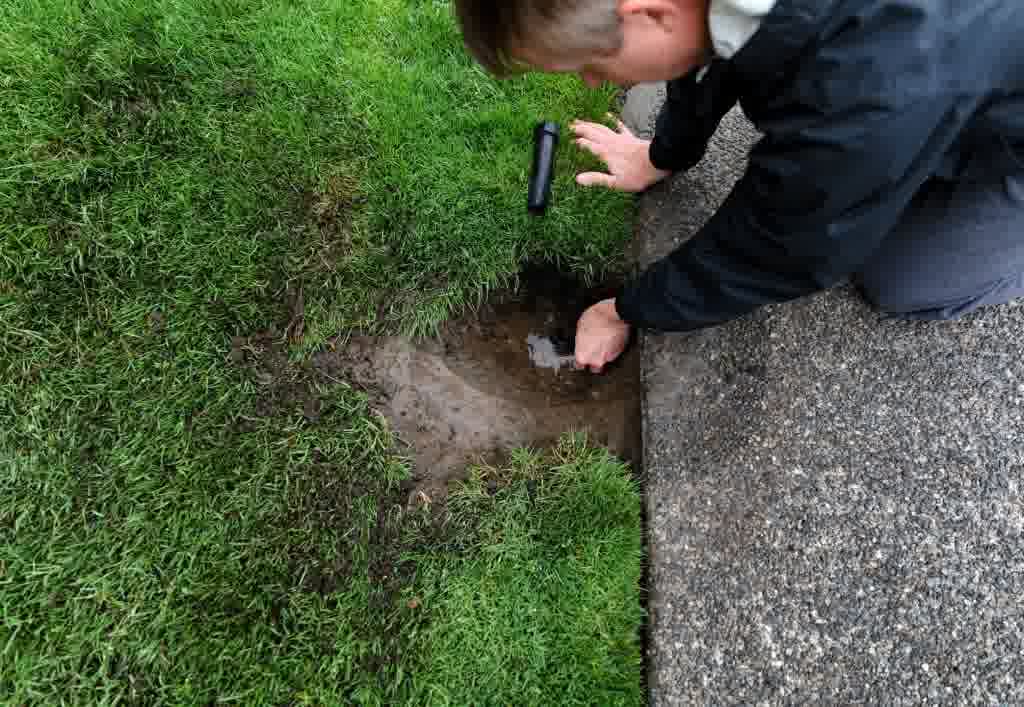 A man is inspecting an irrigation leak.