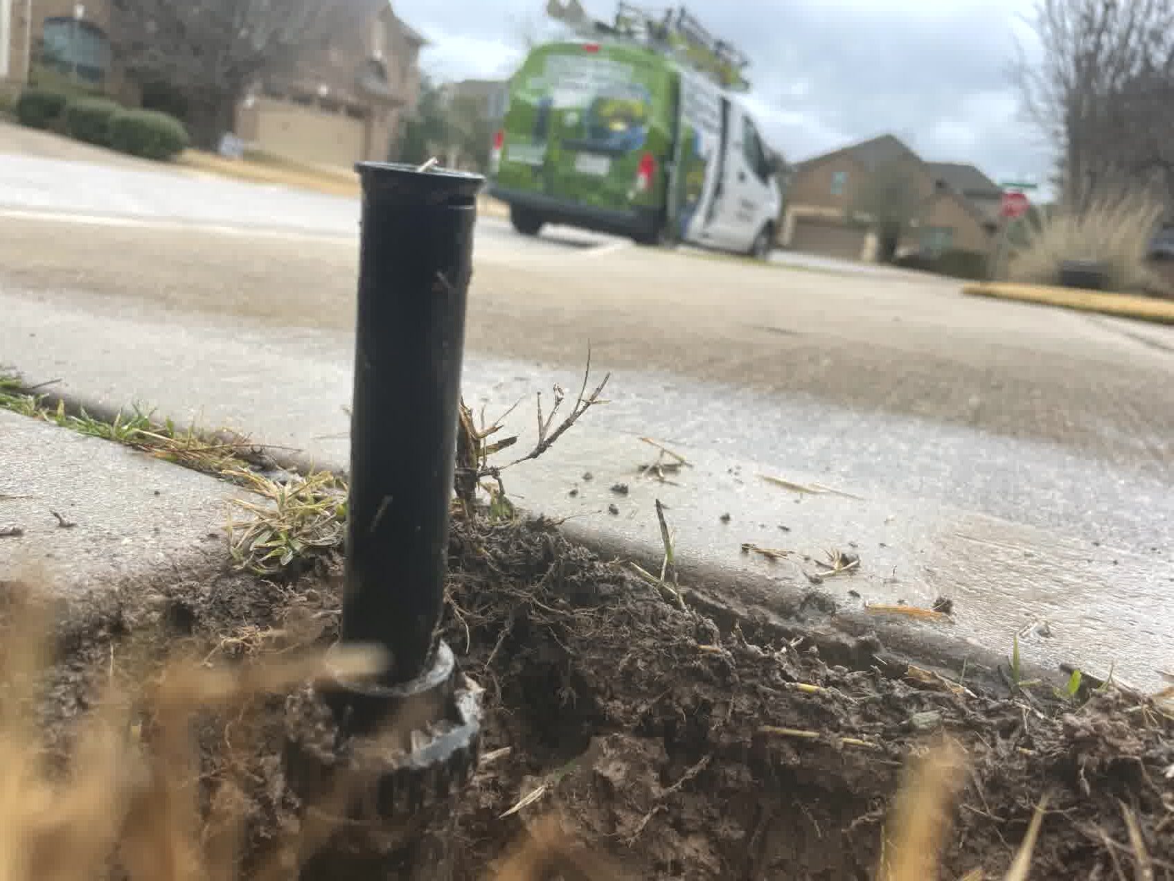 A professionally inspected sprinkler system with a ProGreen Dallas work van in the background.