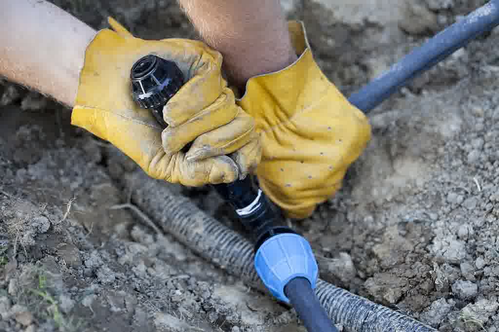 A professional irrigation tech. handling a quick irrigation leak repair.
